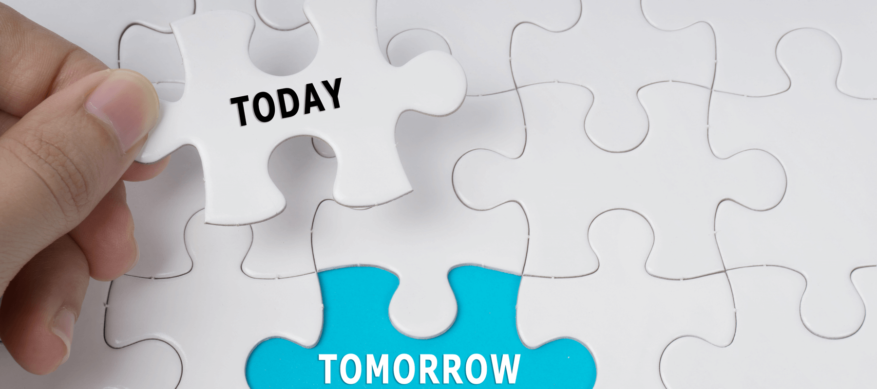 Hand holding puzzle piece that says today uncovering the word tomorrow 
