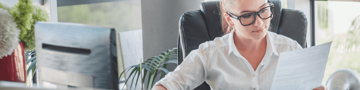 Business woman sitting at desk working on documents