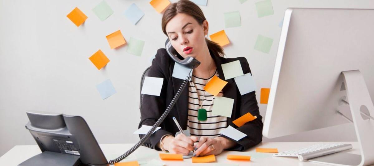 FM Audit concept, busy office manager on the phone covered in post it notes or sticky notes