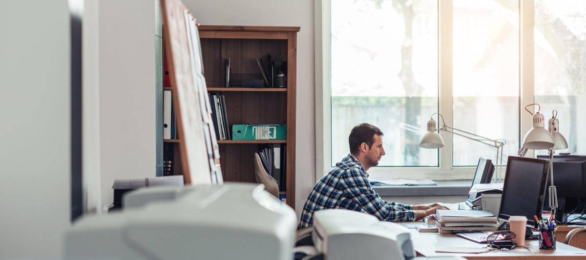 small business office with printer and man working in the background